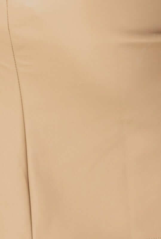 Close-up of faux leather Wylder Skirt highlighting pleat detail and smooth beige fabric.
