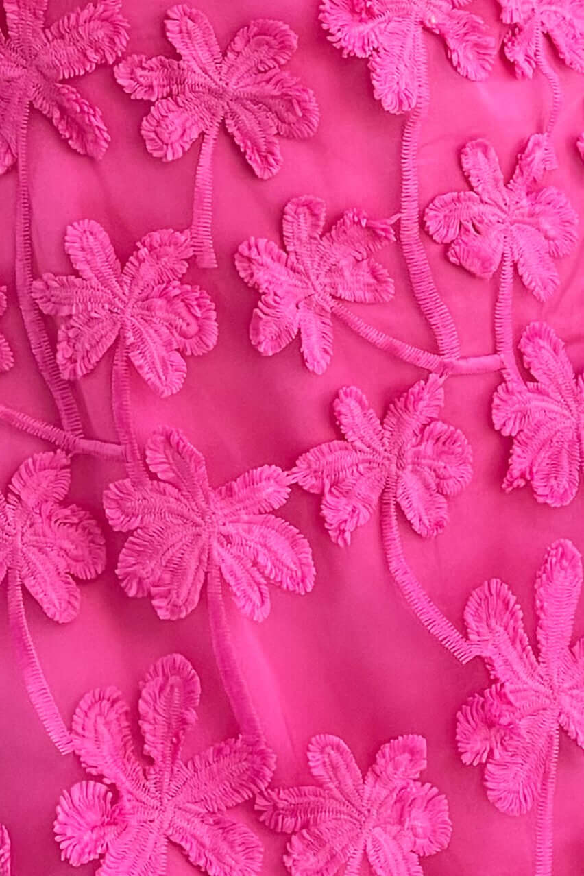 Close-up of tulle embroidered floral detail in vibrant pink on the Xaria Dress.