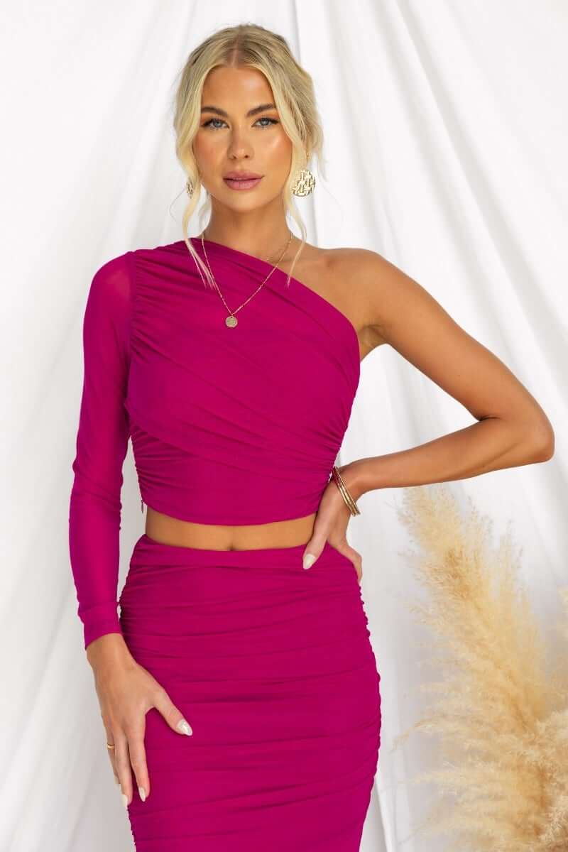 Model wearing a vibrant pink Xylah Top featuring a one-shoulder design and mesh overlay.